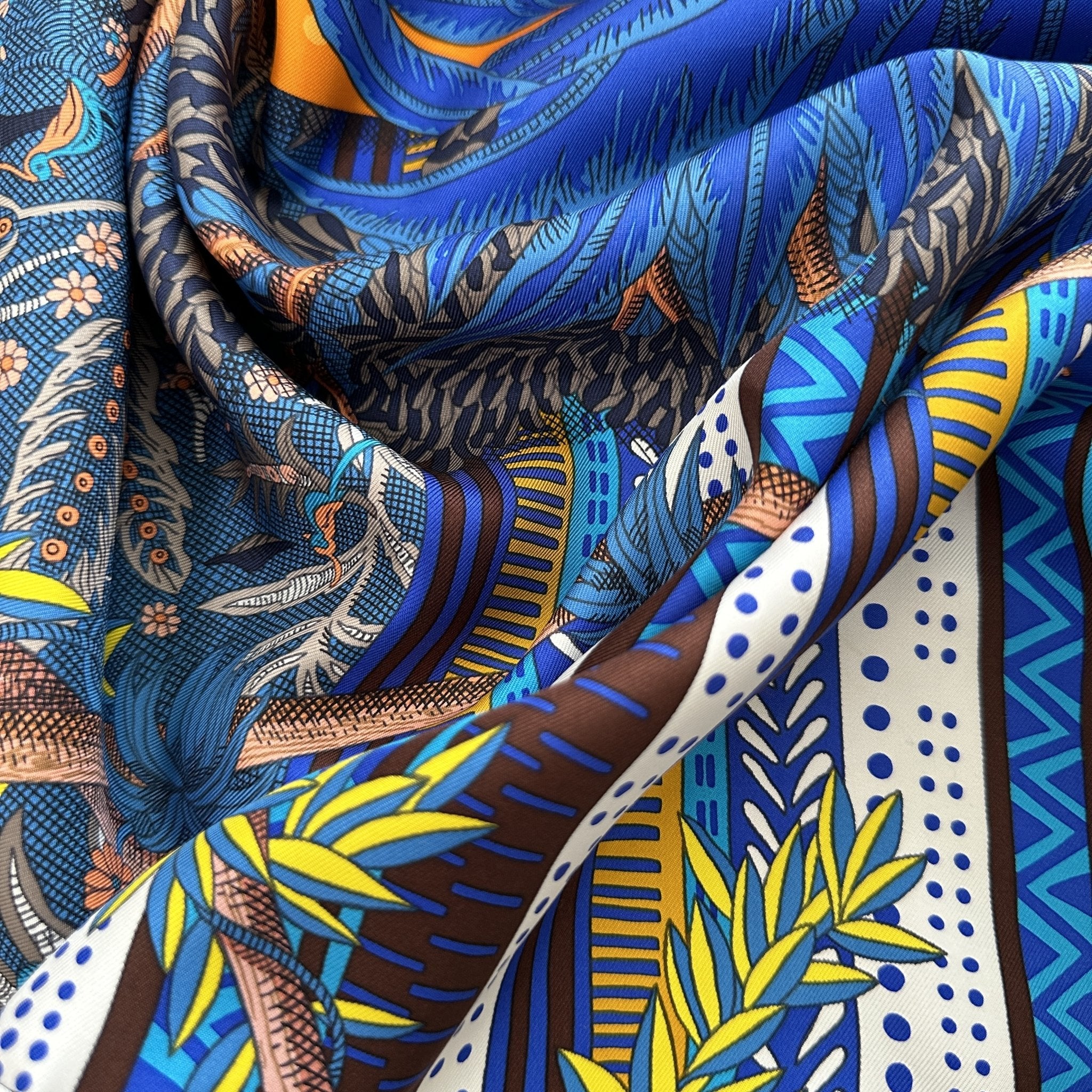 plis du foulard faisant ressortir ses couleurs bleu creme rose jaune