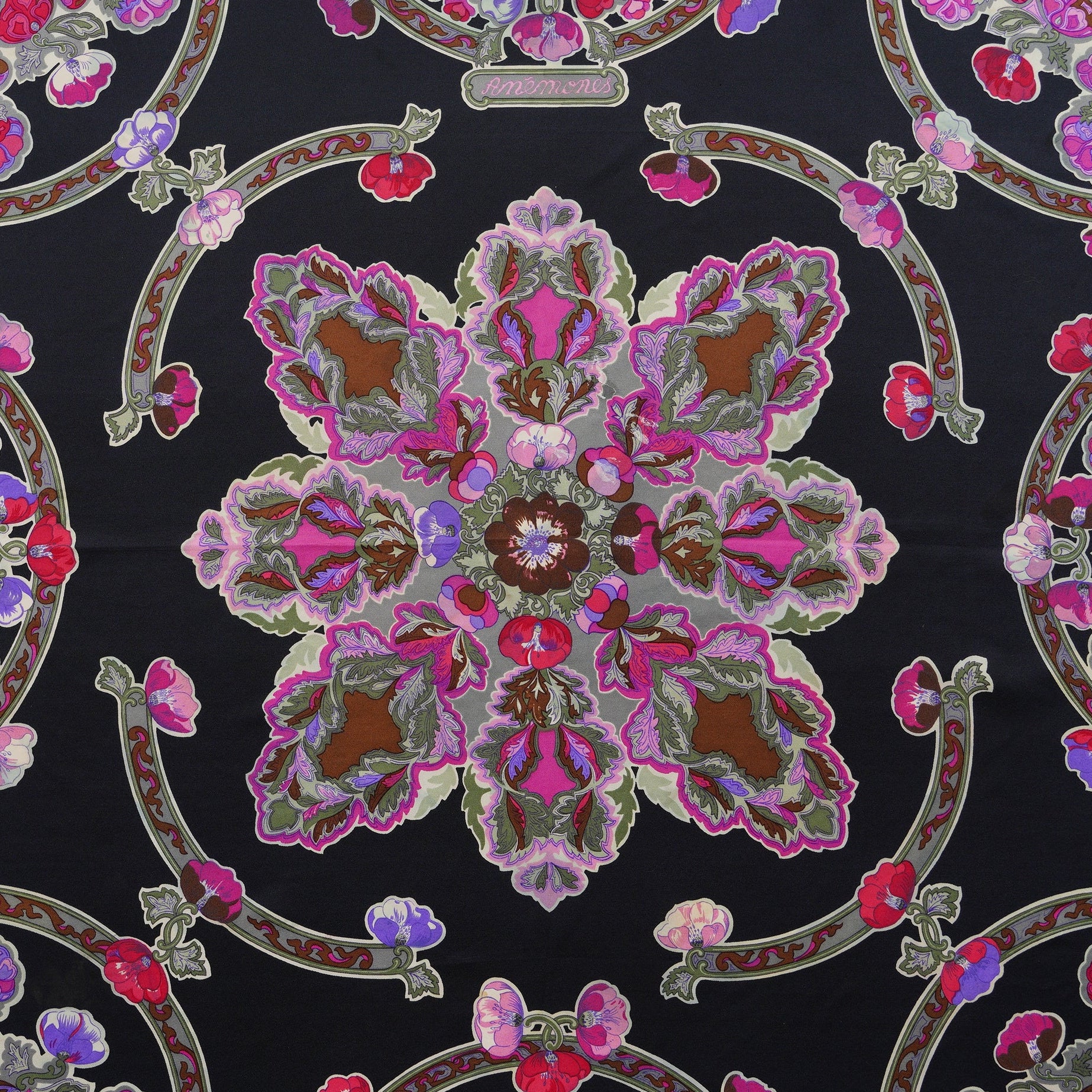 Vue de détail sur la rosace centrale complexe et les motifs floraux sur fond noir du carré Hermès vintage "Anémones".