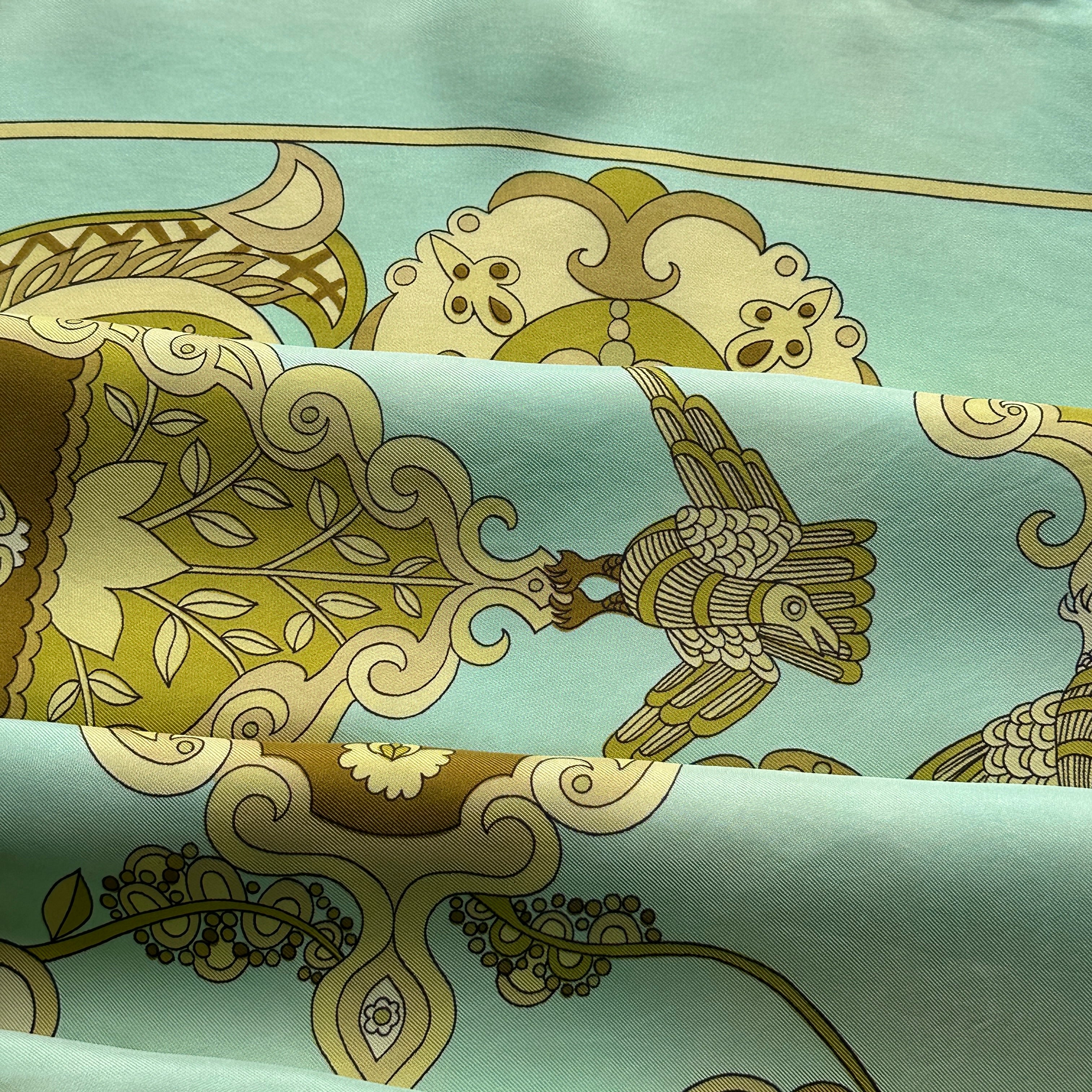 Vue rapprochée des motifs baroques et psychédéliques : volutes, paisley et formes végétales en camaïeu de verts.