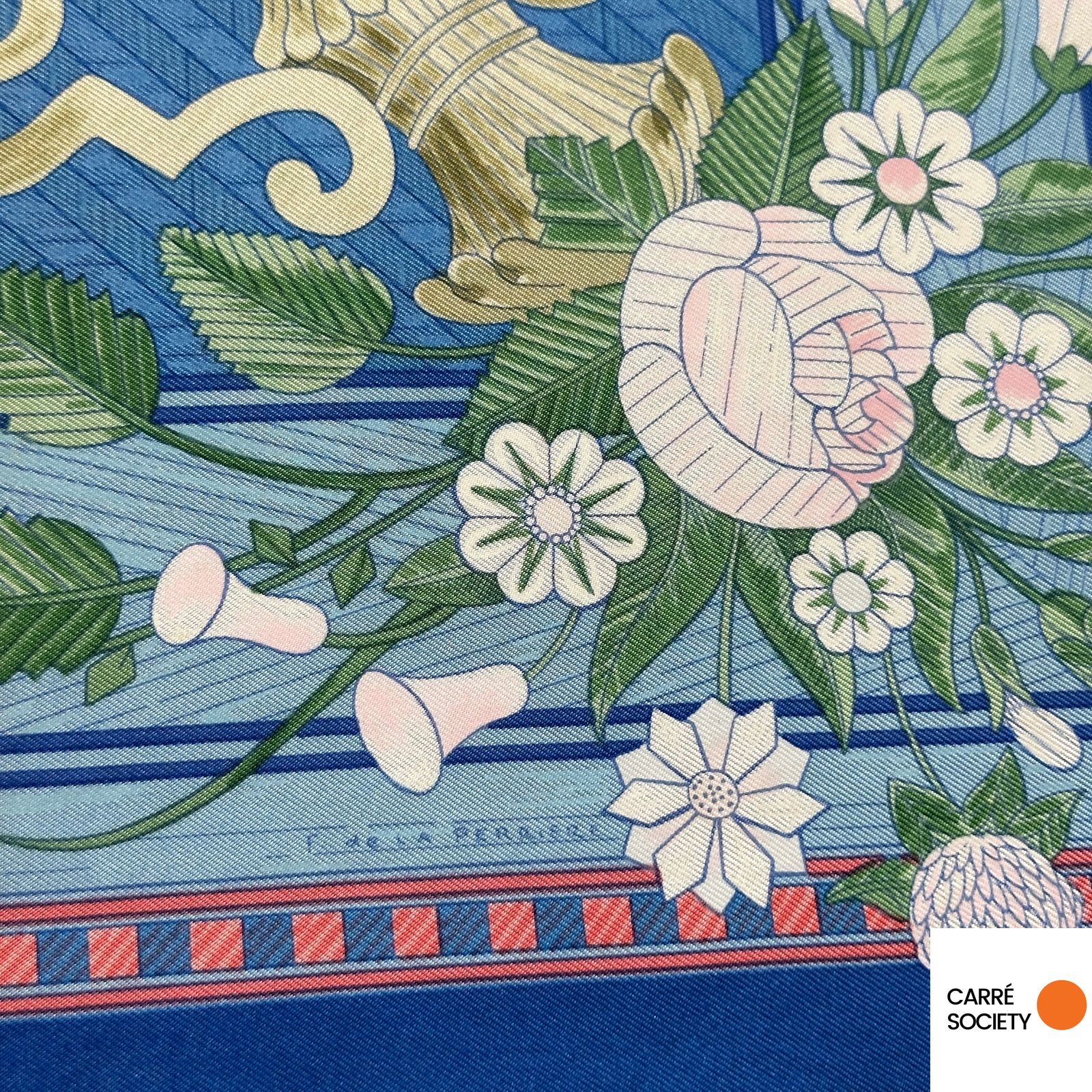 Signature de Françoise de la Perrière sur le foulard Hermès Jeux de Paille, entourée de fleurs et de feuilles finement dessinées.