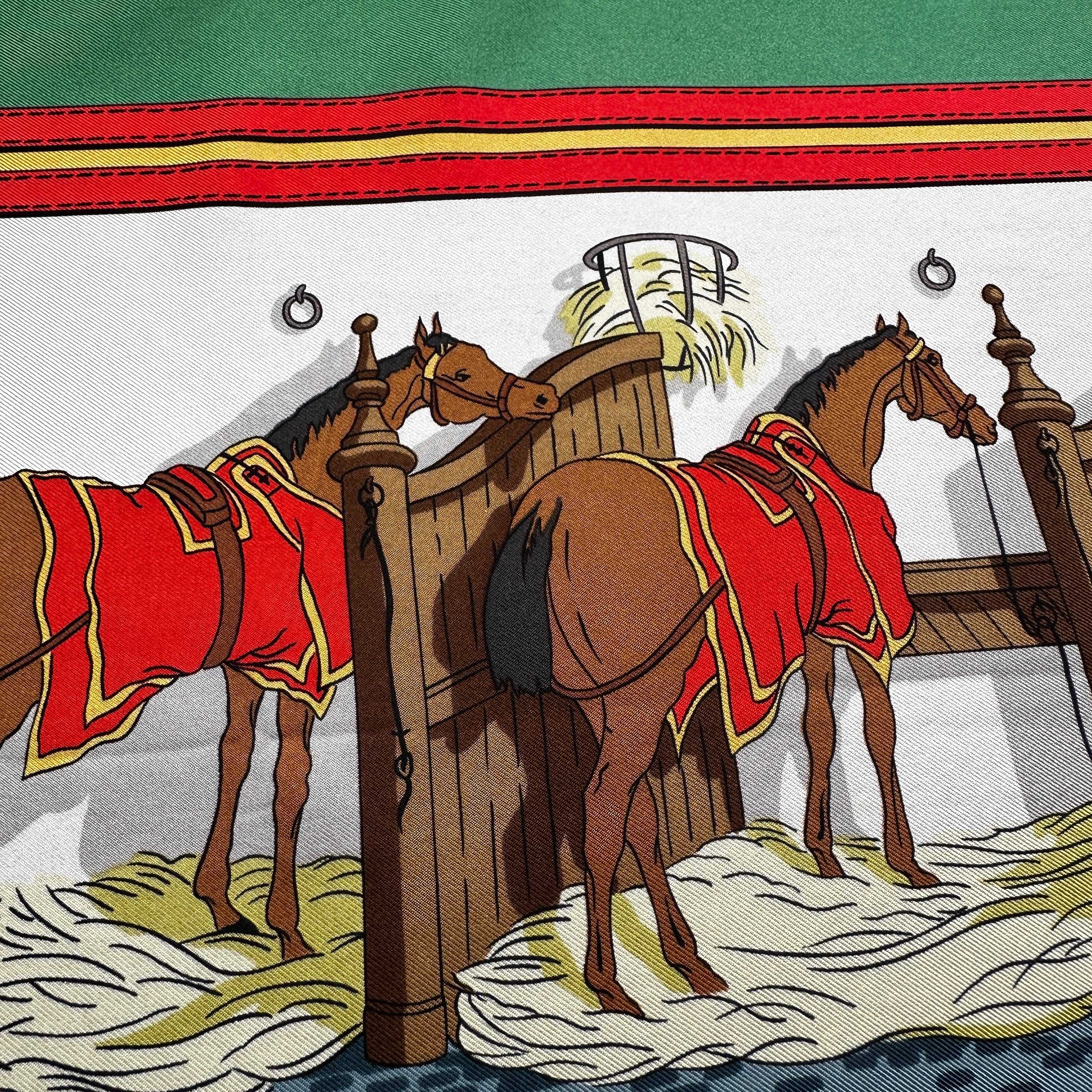 Détail motif chevaux à l'écurie et couvertures rouges